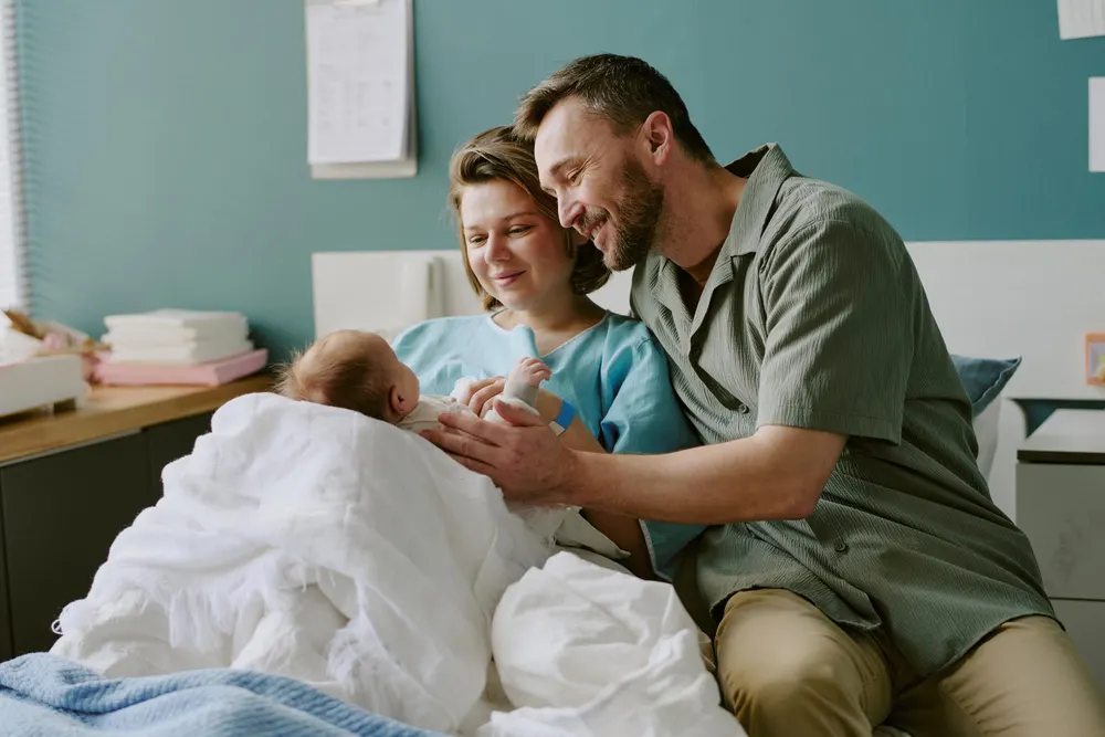 Three generations of a family gathered around a table at home with two babies